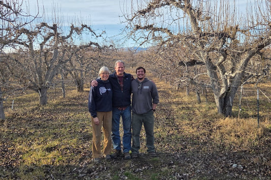 Claire, Hal, & Simon standing in their fruit orchard.
