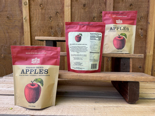 Three bags of freeze dried apples from Whitestone Mountain Orchard, lined up on a set of wooden steps.